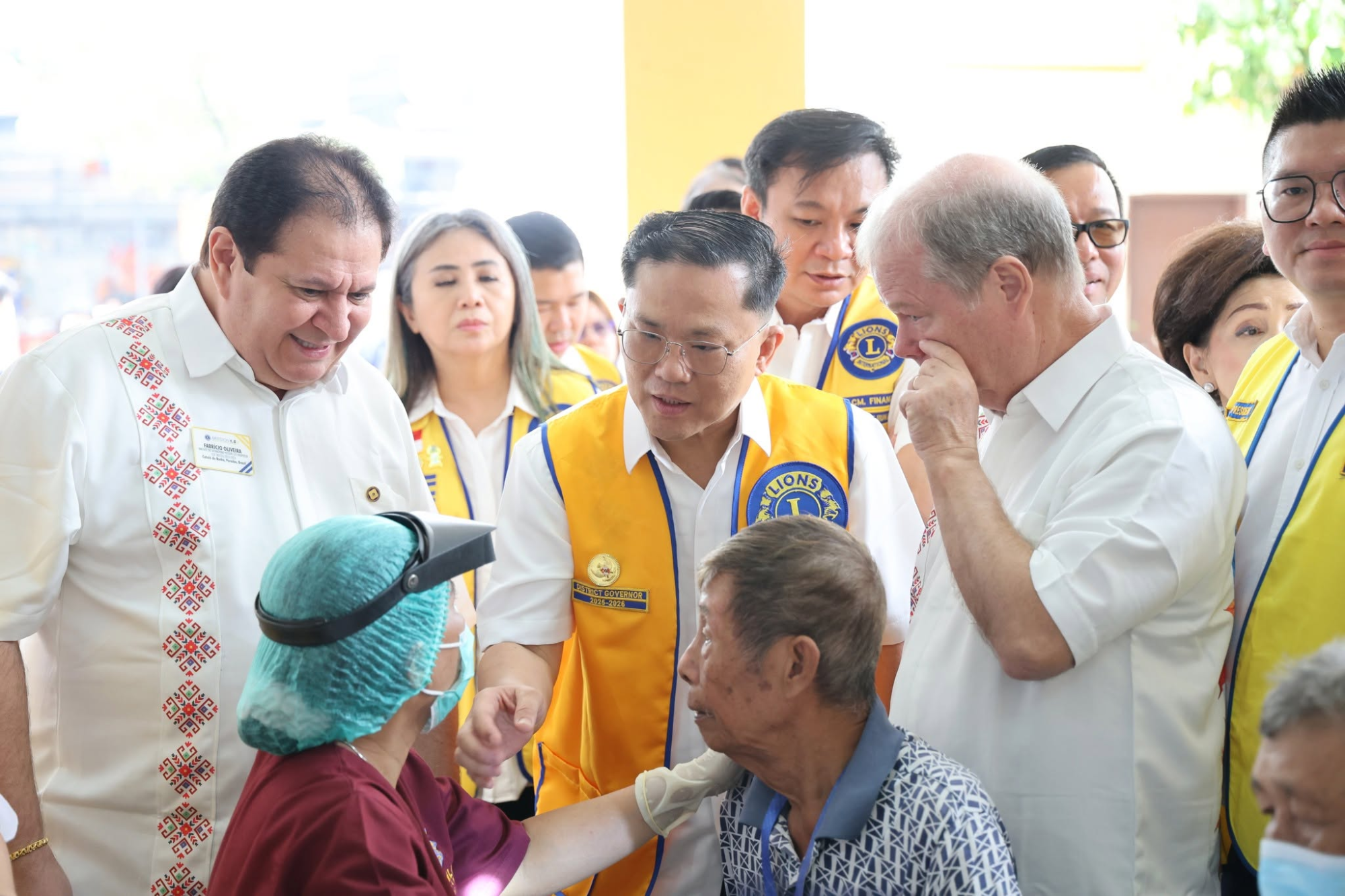 Lions leaders in yellow vests visiting patients at a vision screening